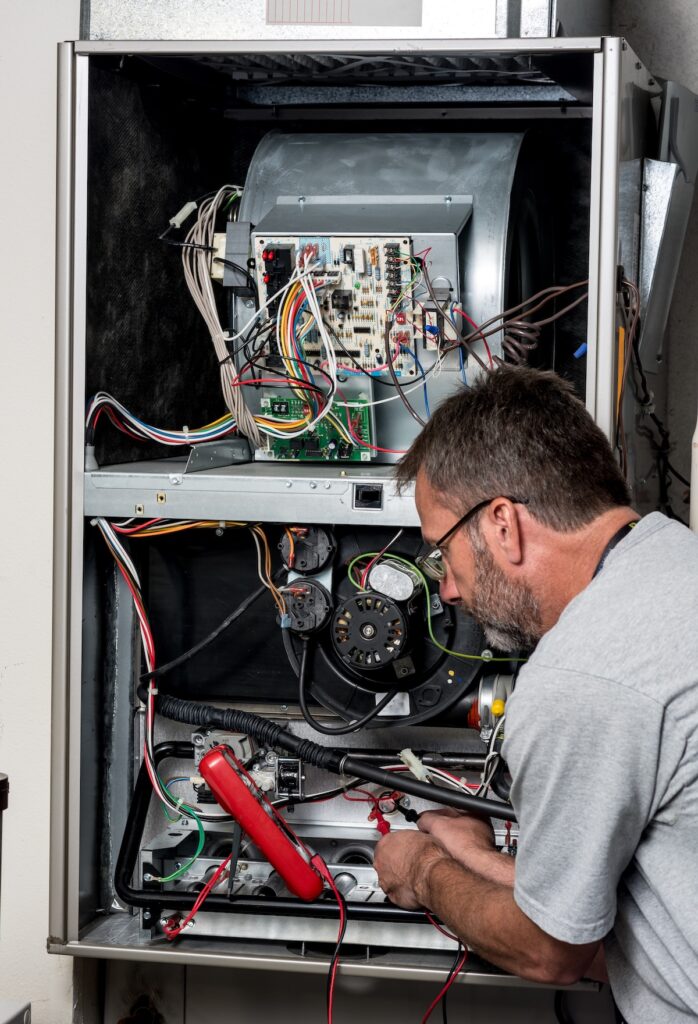 Furnace repair with a voltage meter used by a man
